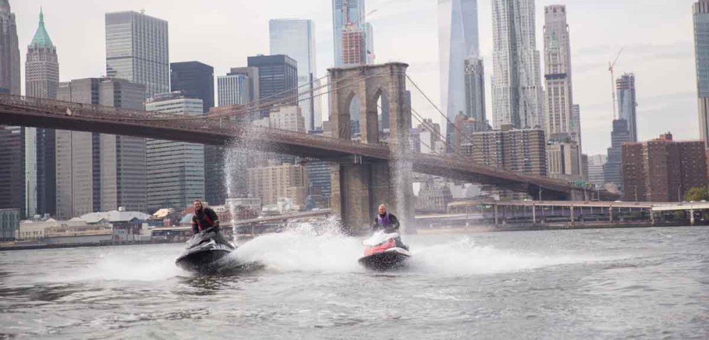 man and woman speeding on jet ski's in nyc